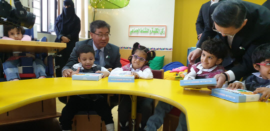포스코건설 이영훈 사장과 주 사우디아라비아 대한민국 대사관 도병욱 대사가 리야드 지역 장애인학교 아이들에게 학용품 선물을 나눠주고 있다. <포스코건설 제공>